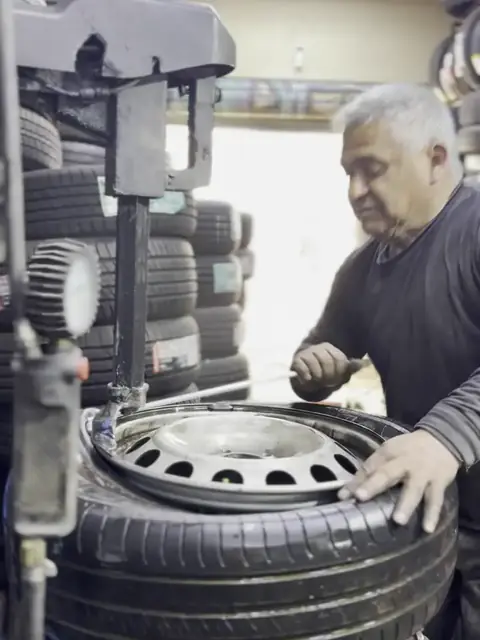 Maestro montando un neumático en la máquina desmontadora